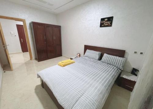 a bedroom with a bed with a white and black comforter at Au dix sept in Dakhla