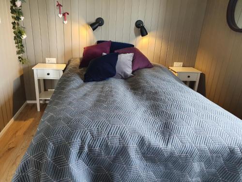 1 dormitorio con 1 cama con almohadas y 2 mesas en Adorable cosy and private new cabin in the south, en Hvolsvöllur