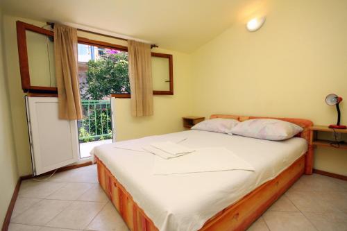 een slaapkamer met een groot bed met een raam bij Studio Stomorska 5239d in Stomorska