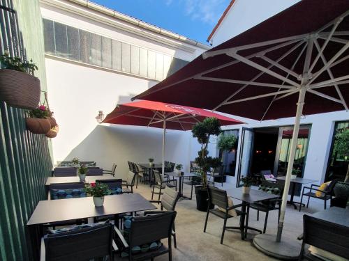 an outdoor patio with tables and chairs with umbrellas at ARGENTA Living 16 in Künzell