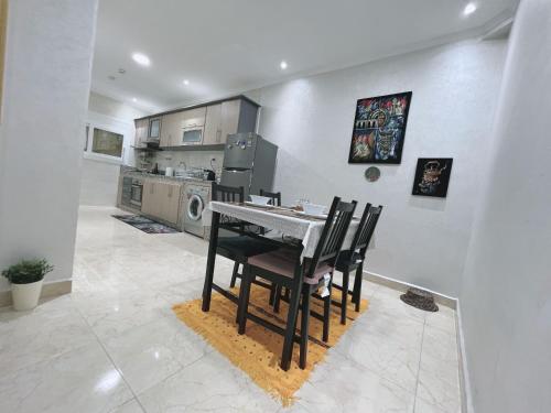 a kitchen with a table and chairs in a room at Au dix sept in Dakhla