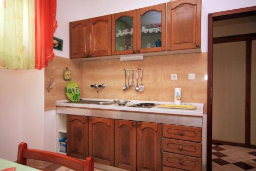 Una cocina con gabinetes de madera y un fregadero. en Apartments by the sea Milna, Brac - 5242, en Milna