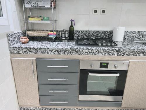 a kitchen with a counter top with a stove top oven at Au dix sept in Dakhla