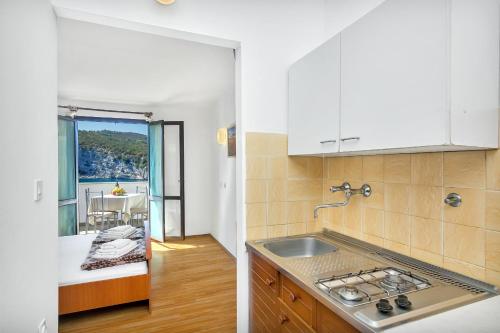 uma cozinha com um lavatório e vista para um quarto em Studio Pokrivenik 5231d em Gdinj