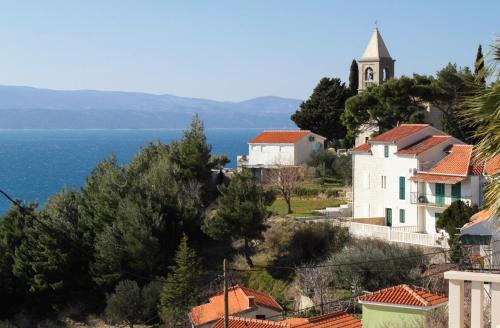 a small town with a church and the ocean at Apartments with a parking space Mimice, Omis - 5251 in Mimice