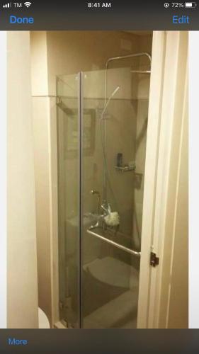 a glass shower in a bathroom with a toilet at Shell Residence MOA Manila by JO Alano in Manila