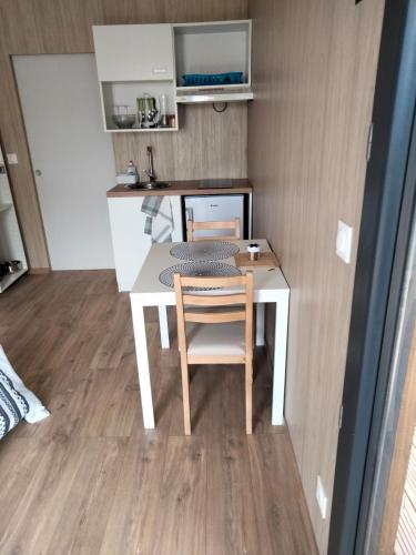 uma pequena cozinha com uma mesa e uma cadeira em Duplex atypique en bois entre ville et verdures em La Chapelle-Saint-Mesmin