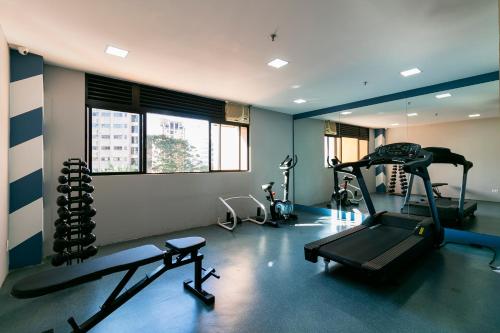 a gym with several tread machines in a room at Suíte na região dos hospitais in Sao Paulo