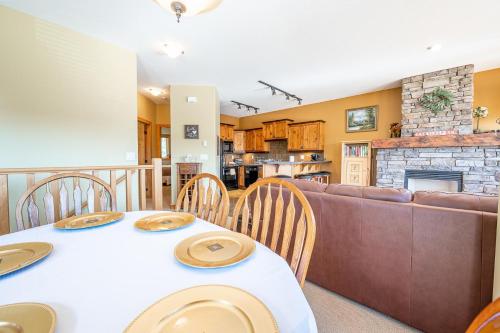 a living room with a table and a couch at Bear's Paw Chalet - Amazing Location & Ski In-Out in Big White
