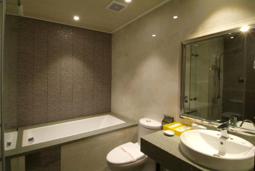 a bathroom with a toilet and a sink and a bath tub at The Cloud Hotel in Taichung