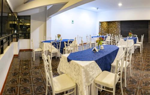 een feestzaal met blauwe en witte tafels en stoelen bij Hotel Huaytapallana suites in Huancayo
