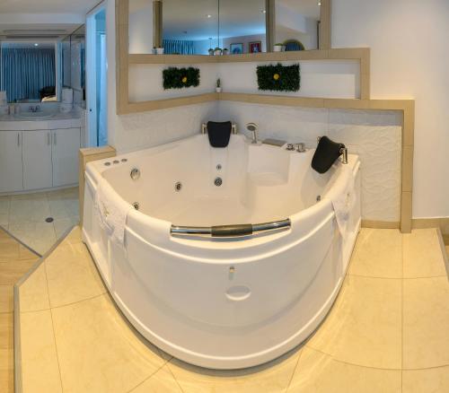 y baño con bañera blanca grande. en Hotel Huaytapallana suites, en Huancayo