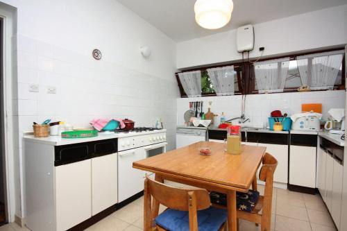 a kitchen with a wooden table and white cabinets at Double Room Banjol 5077a in Rab