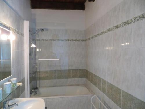 une salle de bain avec une baignoire et un lavabo dans l'établissement Maison périgourdine avec piscine, 7 pers, jardin, cheminée - FR-1-616-111, à Saint-Avit-Sénieur