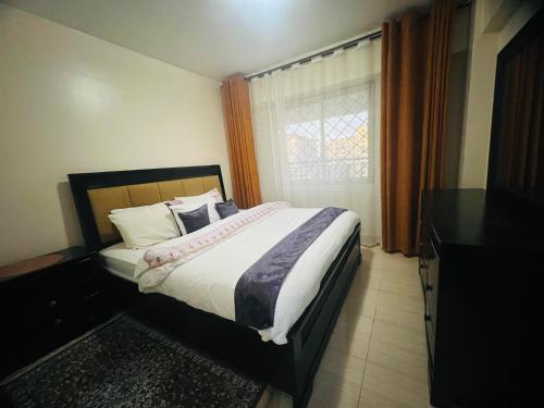 a bedroom with a large bed and a window at Eastleigh Executive Furnished Apartments next to BBS Mall in Nairobi
