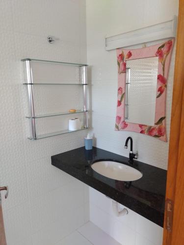 a bathroom with a sink and a mirror at POUSADA ALVE VERDe in Capitólio