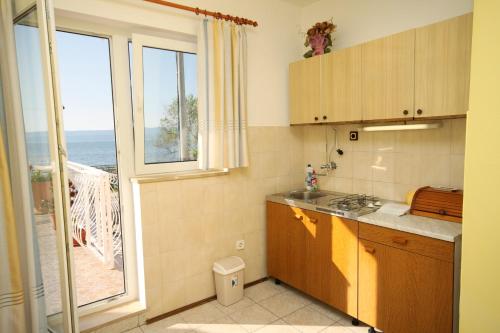 een keuken met uitzicht op de oceaan vanuit een raam bij Apartments by the sea Duce, Omis - 5275 in Dugi Rat