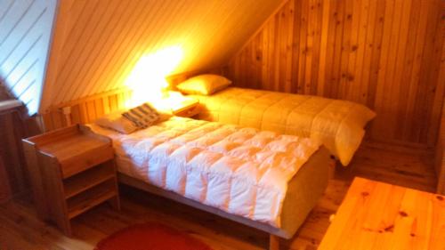 Saare Guest Apartment في Saare: غرفة نوم بسريرين ومصباح في الغرفة
