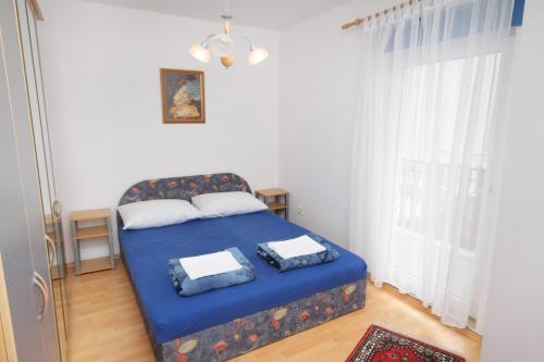 a bedroom with a blue bed and a window at Apartments with a parking space Jadranovo, Crikvenica - 5285 in Jadranovo