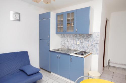 a kitchen with blue cabinets and a blue couch at Apartments with a parking space Jadranovo, Crikvenica - 5285 in Jadranovo