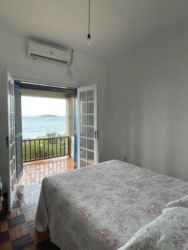 sypialnia z łóżkiem i widokiem na ocean w obiekcie Pé na areia 6 quartos Ingleses w mieście Florianópolis