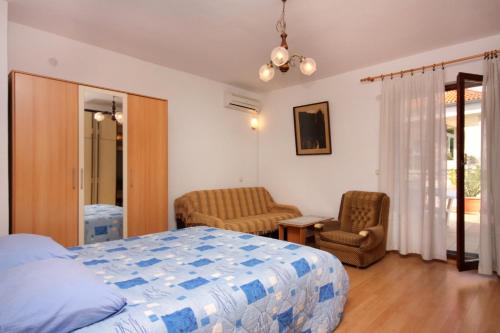 a bedroom with a bed and two chairs in it at Apartments and rooms with parking space Vrbnik, Krk - 5301 in Vrbnik