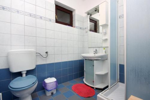 a blue and white bathroom with a toilet and a sink at Apartments and rooms with parking space Vrbnik, Krk - 5301 in Vrbnik