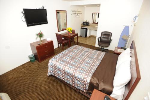 a hotel room with a bed and a flat screen tv at Victoria Motel in Ventura