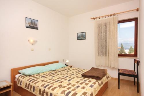 um quarto com uma cama e uma janela em Double Room Vrbnik 5301b em Vrbnik