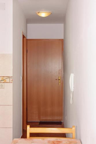 a wooden door in a room with a phone at Apartments with a parking space Malinska (Krk) - 5289 in Malinska