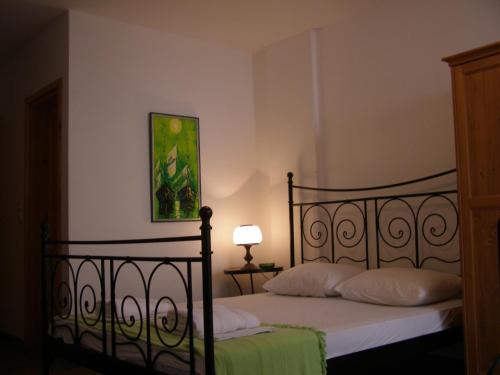 a bedroom with a bed with white sheets and a lamp at Palastura Apartments in Ulcinj