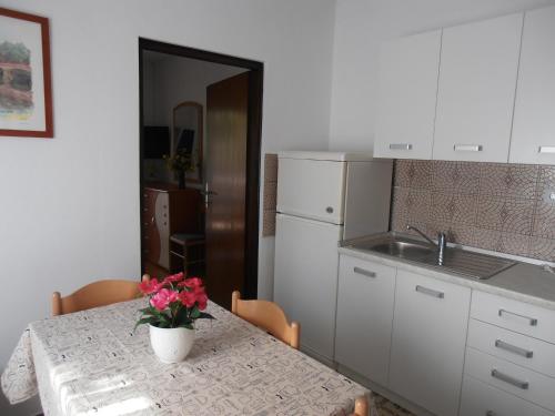 a kitchen with a table with a vase of flowers on it at Apartments with a parking space Sveti Anton, Krk - 5288 in Sveti Anton