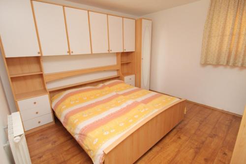 a small bedroom with a bed and white cabinets at Apartments with a parking space Selce, Crikvenica - 5287 in Selce
