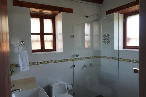 a bathroom with a glass shower and a sink at Hotel Campestre Casa La María in Firavitoba