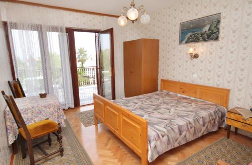 1 dormitorio con cama, mesa y escritorio en Apartment Malinska 5284a en Malinska