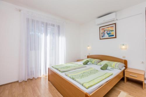 a bedroom with a bed and a large window at Apartments with a parking space Vantacici, Krk - 5313 in Malinska