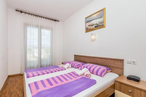 two beds in a room with purple pillows at Apartment Vantacici 5313c in Malinska
