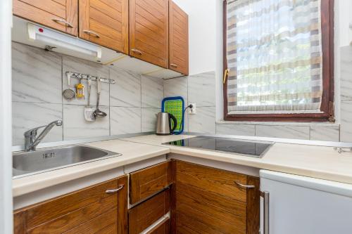 a kitchen with wooden cabinets and a sink at Apartment Vantacici 5313c in Malinska