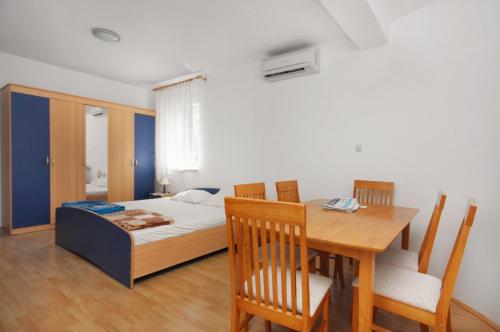 a bedroom with a bed and a table and chairs at Apartments and rooms with parking space Sveti Vid, Krk - 5323 in Sveti Vid-Miholjice