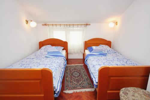two beds in a small room with a window at Apartments by the sea Malinska (Krk) - 5290 in Vantačići