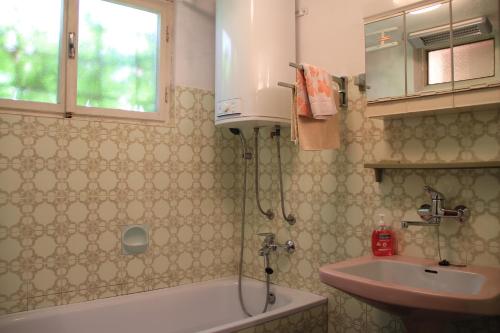 a bathroom with a sink and a bath tub and a sink at Apartment Malinska 5290b in Vantačići
