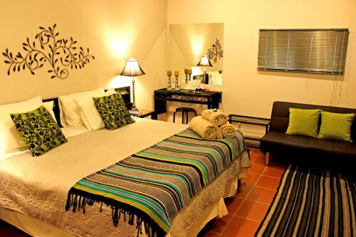 a bedroom with a large bed and a couch at Carters Rest Guesthouse in Kimberley