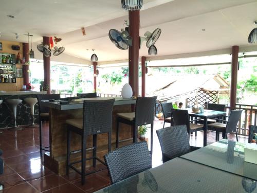 a restaurant with a bar with chairs and tables at Baansanook Resort & Swimming Pool in Ko Chang