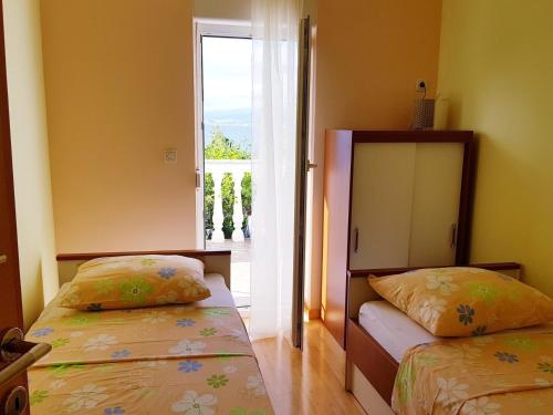 sypialnia z 2 łóżkami i oknem z widokiem w obiekcie Apartments by the sea Njivice, Krk - 5295 w mieście Nijvice