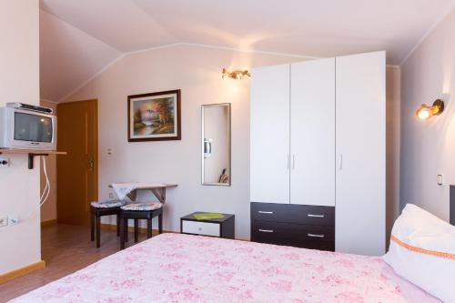 a bedroom with a bed and a tv and a table at Double Room Krk 5294b in Krk