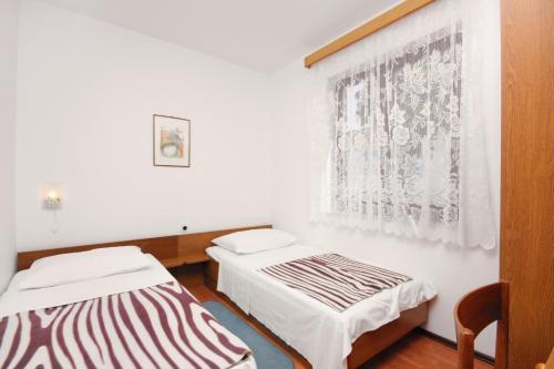 a room with two beds and a window at Apartments by the sea Njivice, Krk - 5311 in Njivice