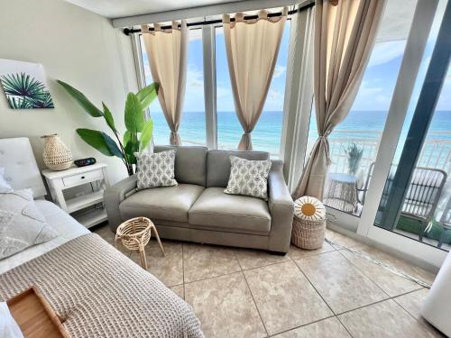 a bedroom with a couch in front of the ocean at Beach Oasis 704 Lovely Daytona ocean front for 5 sleeps up to 12 in Daytona Beach
