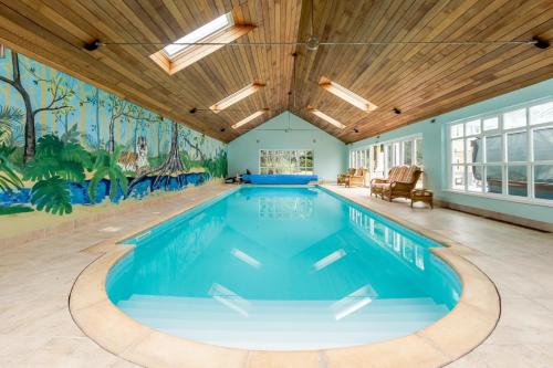 a swimming pool in a house with a mural on the wall at Cottage In Norfolk Sleeps 23 - Private Pool, Fishing Lake, Hot Tub Ref 99008sc in Hockham