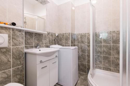 y baño con aseo, lavabo y ducha. en Apartments and rooms with parking space Krk - 5294, en Krk