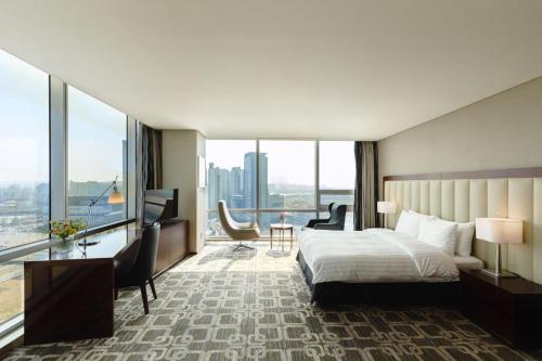 a hotel room with a bed and a large window at Sono Calm Goyang in Goyang